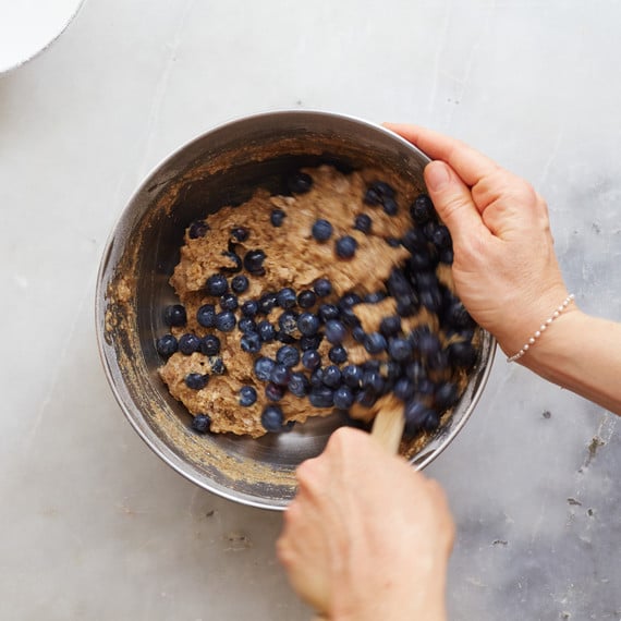 ingredients to make vegan blueberry muffins being mixed in a bowl