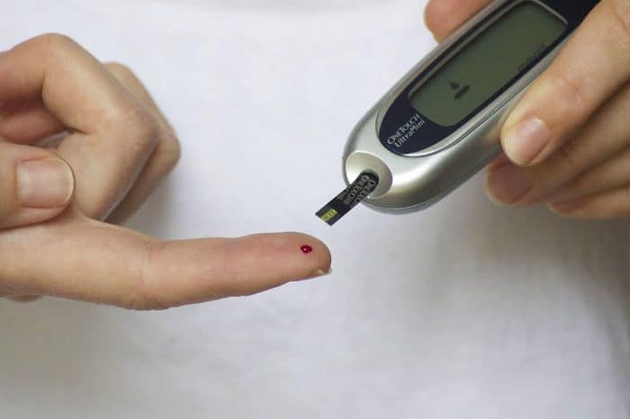 checking blood sugar level using blood glucose meter after taking vegan diet